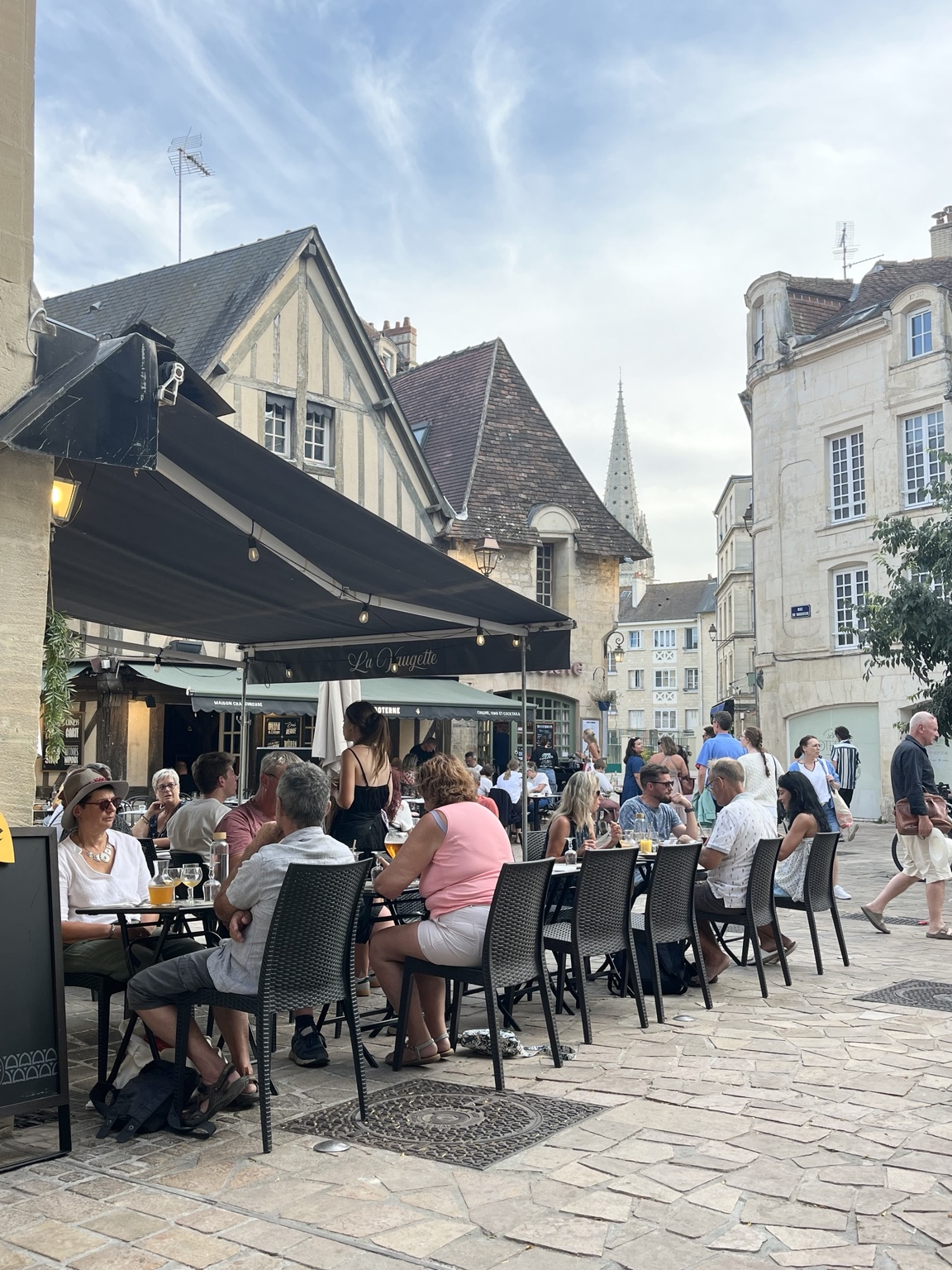 Terrasse animée de La Vauguette au milieu des maisons anciennes